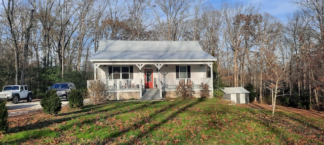 bungalow featuring covered porch, a shed, and a front yard