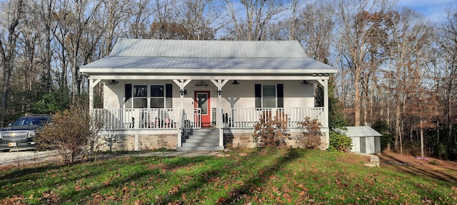 bungalow-style home with covered porch, a storage shed, and a front lawn