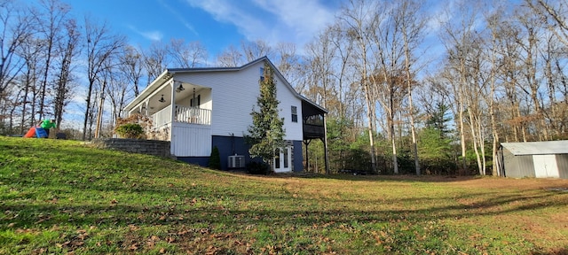 view of property exterior featuring a lawn and a storage shed