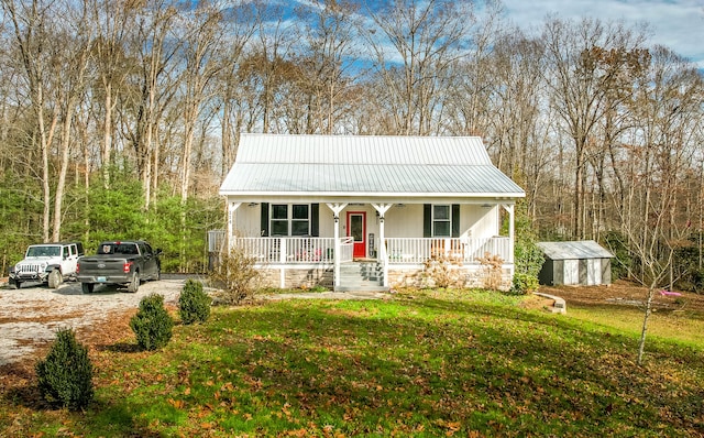 view of front of property featuring a porch, a shed, and a front lawn