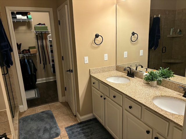 bathroom featuring tile patterned flooring, vanity, and a shower with door