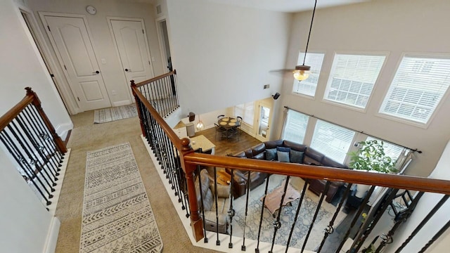 stairs with carpet and a high ceiling