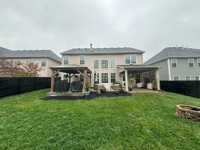 rear view of property featuring a gazebo, a patio, an outdoor living space with a fire pit, and a lawn