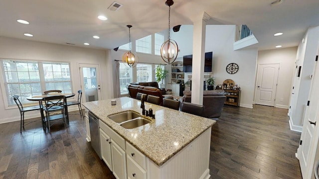 kitchen with dark hardwood / wood-style flooring, a center island with sink, hanging light fixtures, and sink