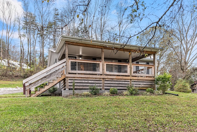 rear view of property featuring a lawn