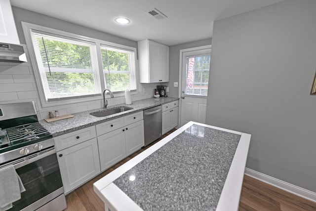 kitchen featuring appliances with stainless steel finishes, dark hardwood / wood-style flooring, tasteful backsplash, sink, and white cabinetry