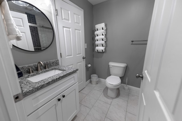 bathroom with vanity, toilet, and a shower with shower door