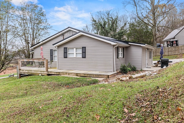 view of side of home featuring a wooden deck and a yard