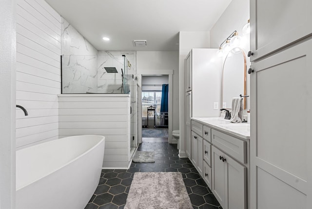 full bathroom featuring a stall shower, visible vents, toilet, a freestanding bath, and vanity