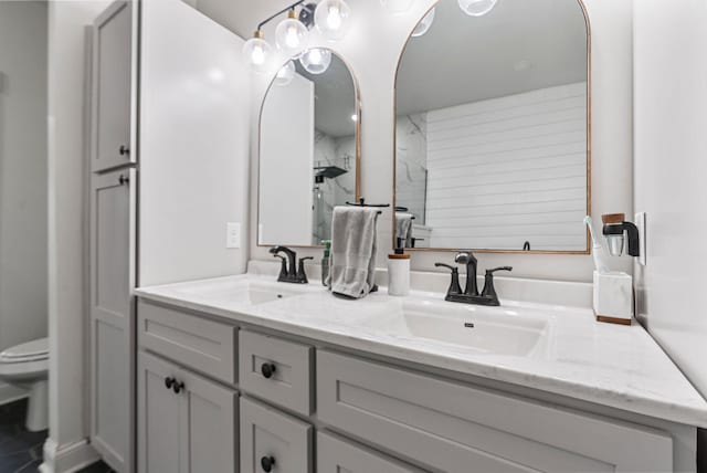 full bath with toilet, double vanity, a shower, and a sink