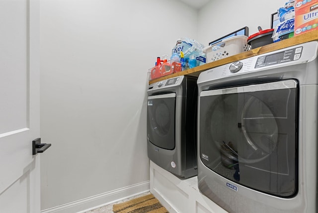 laundry room with laundry area, washing machine and dryer, and baseboards