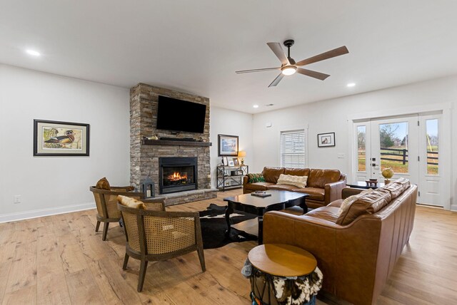 living area featuring recessed lighting, a fireplace, a ceiling fan, baseboards, and light wood-type flooring