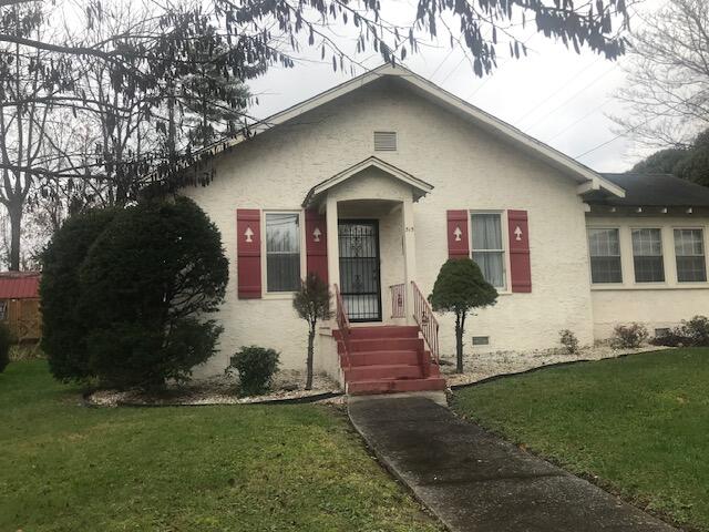 bungalow-style home with a front yard