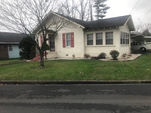 view of front of home with a carport and a front lawn