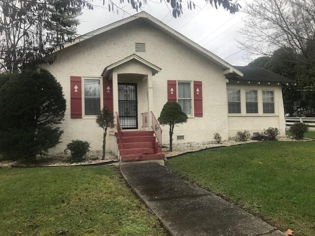 bungalow-style home with a front lawn