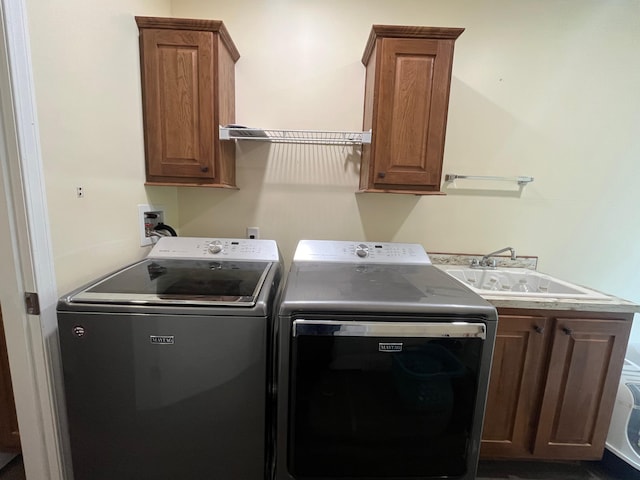 washroom featuring cabinets, washing machine and dryer, and sink