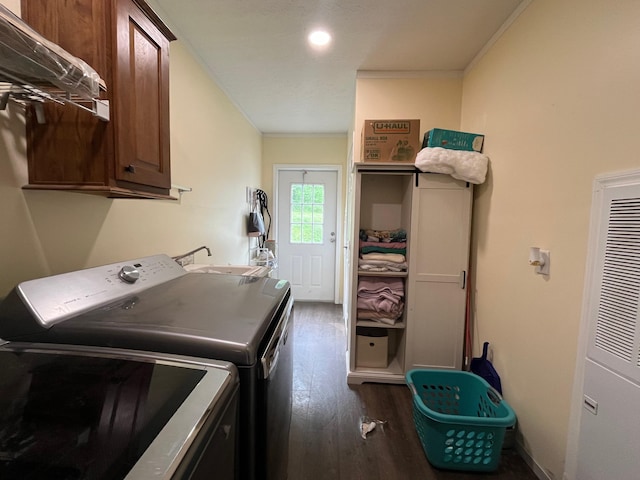 clothes washing area featuring cabinets, crown molding, sink, washer and dryer, and dark hardwood / wood-style floors