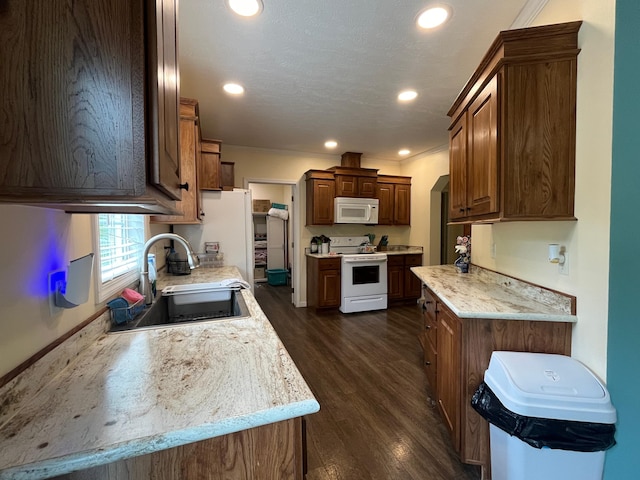 kitchen with sink, dark hardwood / wood-style floors, white appliances, and ornamental molding