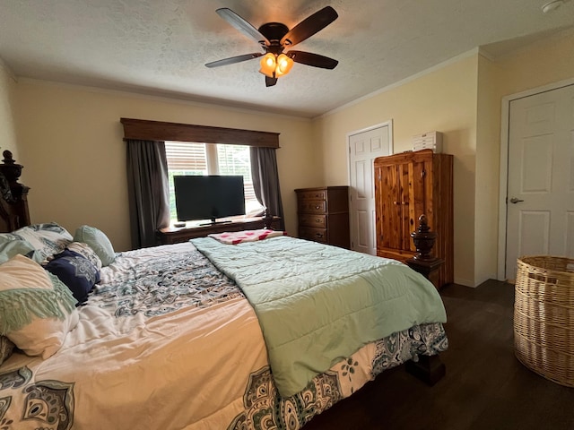 bedroom featuring ceiling fan, dark hardwood / wood-style floors, ornamental molding, and a textured ceiling