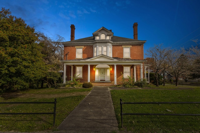 view of front of property with a lawn and a porch