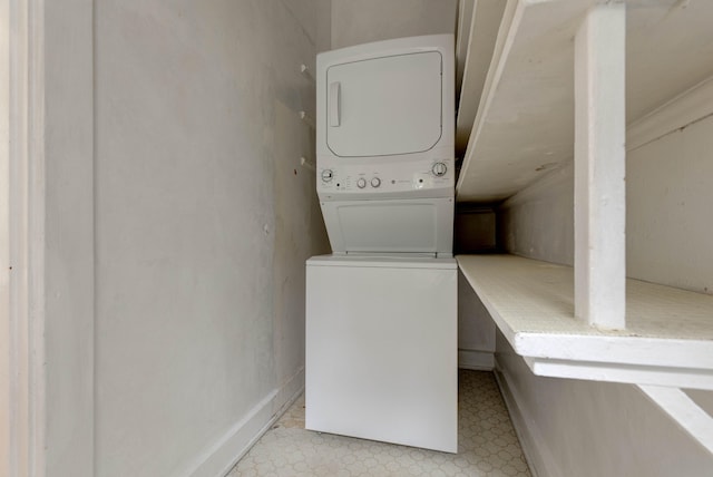 clothes washing area with stacked washer / dryer