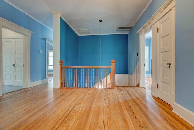 unfurnished room with light wood-type flooring and crown molding