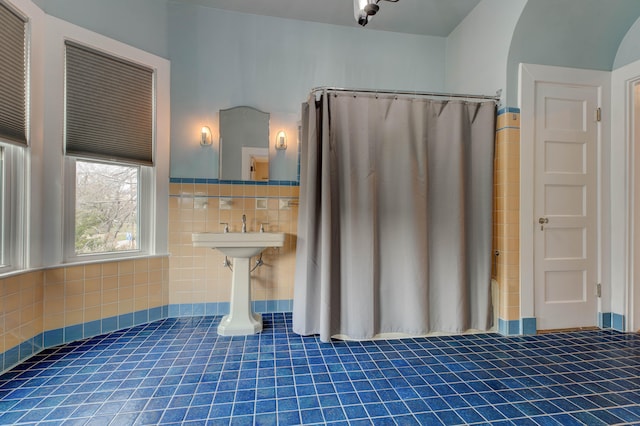 bathroom with tile patterned floors, tile walls, and shower / tub combo with curtain