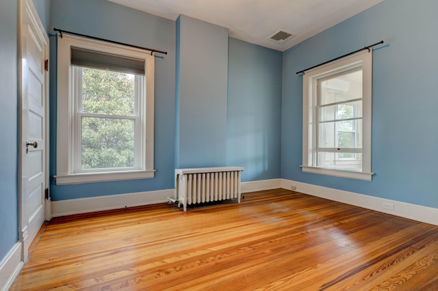 empty room with radiator and light hardwood / wood-style flooring