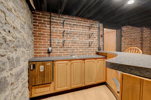 bar with sink and light wood-type flooring