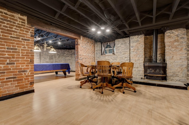 dining room featuring hardwood / wood-style floors, a wood stove, and pool table