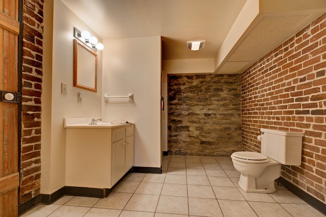 bathroom featuring tile patterned floors, vanity, and brick wall