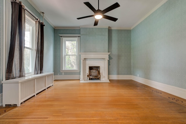 unfurnished living room with crown molding, a healthy amount of sunlight, and light wood-type flooring