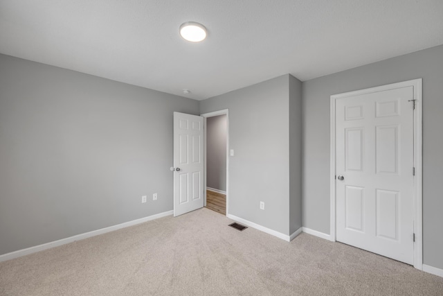 unfurnished bedroom with light colored carpet