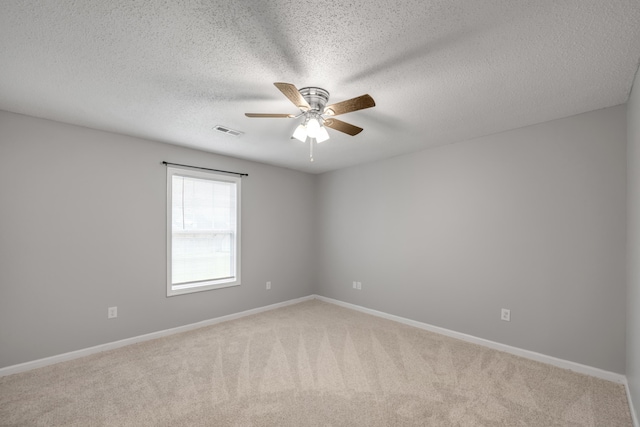 carpeted empty room with a textured ceiling and ceiling fan