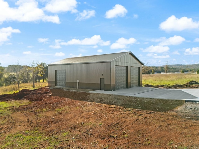 view of outdoor structure featuring a rural view and a garage