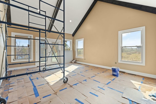 spare room with plenty of natural light and high vaulted ceiling