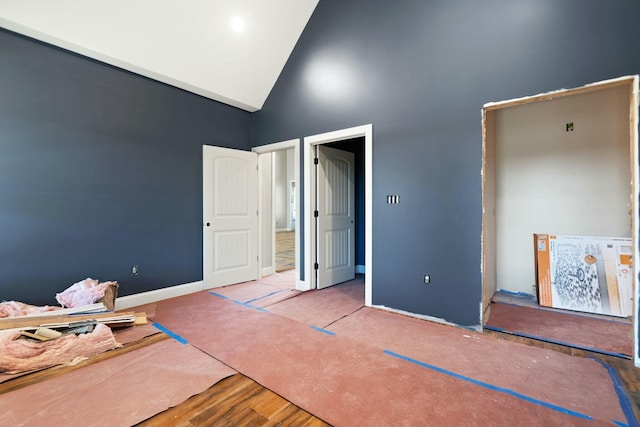 unfurnished bedroom featuring hardwood / wood-style floors and high vaulted ceiling