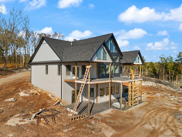 back of property featuring a balcony and a patio