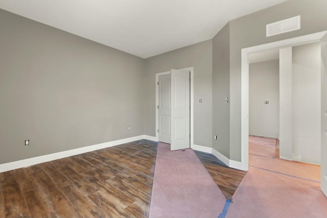 unfurnished bedroom featuring dark hardwood / wood-style floors and a closet