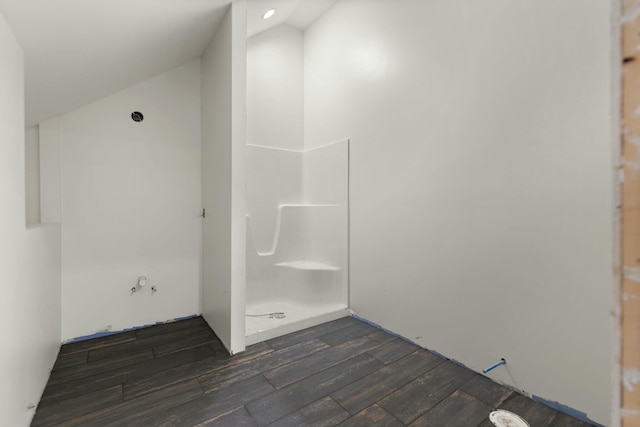 bathroom featuring a shower, wood-type flooring, and vaulted ceiling