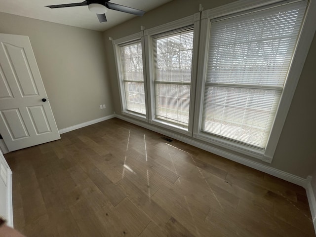 spare room with ceiling fan and dark hardwood / wood-style floors