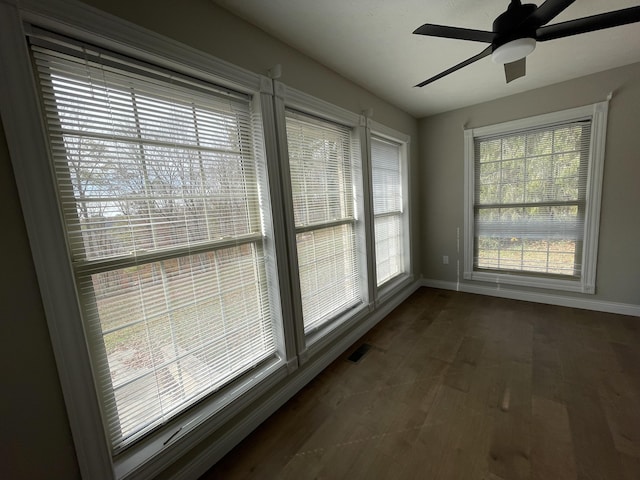 interior space featuring a wealth of natural light, dark hardwood / wood-style floors, and ceiling fan