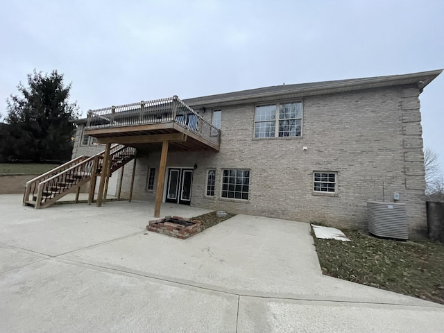 rear view of house featuring central AC, a deck, and a patio