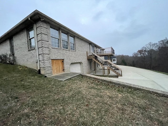 view of side of home featuring a garage, a wooden deck, and a yard