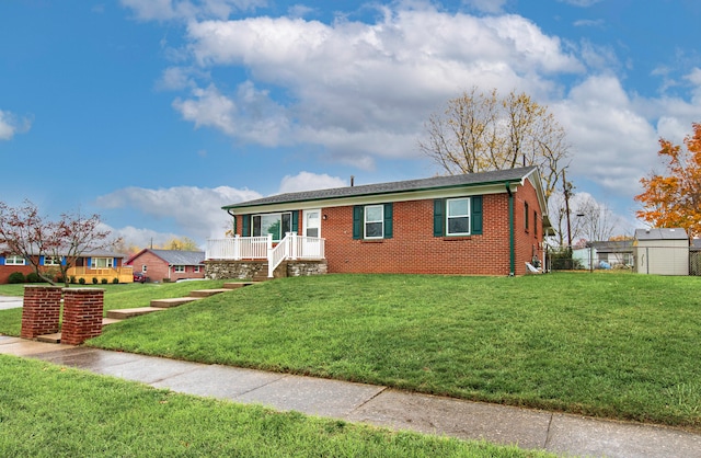 view of front of house featuring a front lawn and a shed