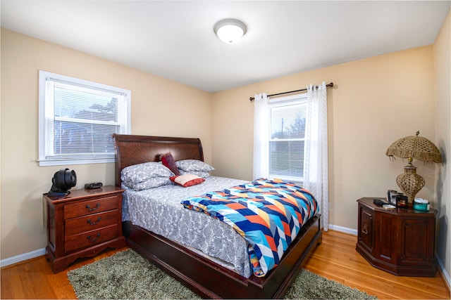 bedroom with multiple windows and light hardwood / wood-style floors