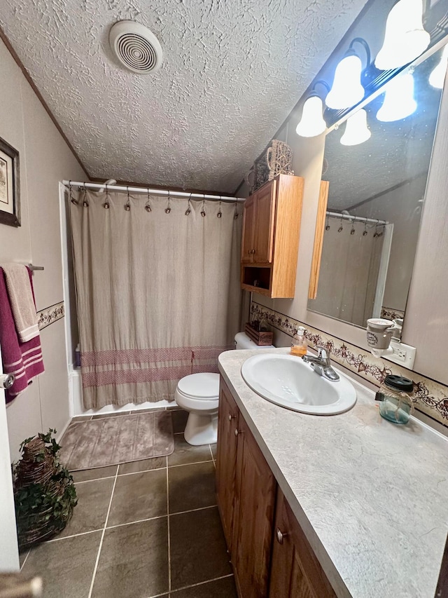 full bathroom featuring tile patterned floors, vanity, shower / bath combination with curtain, and a textured ceiling