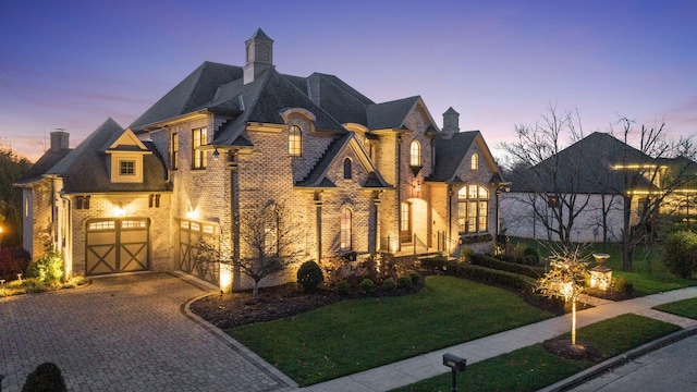 french country style house with a garage and a yard