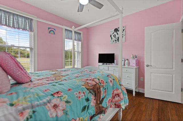 bedroom featuring dark hardwood / wood-style flooring, multiple windows, and ceiling fan