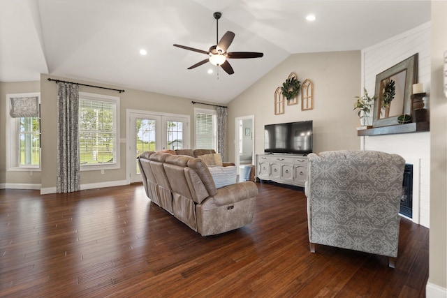 living room featuring ceiling fan, dark wood-type flooring, lofted ceiling, and a brick fireplace